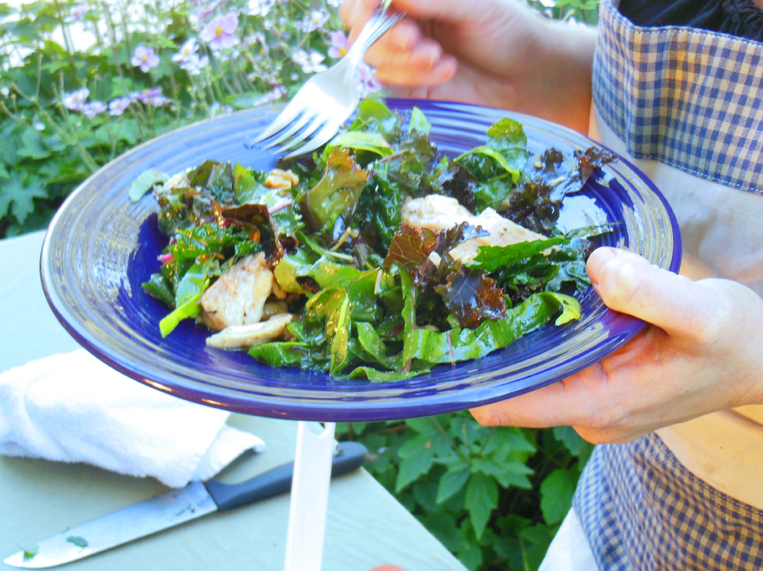 Cooking kale and swiss chard salad with walnuts and raisins.