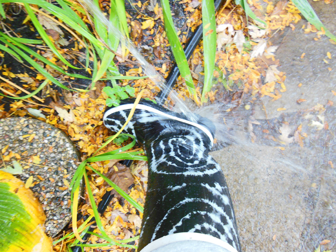 Washing muddy boots in rain barrel water.